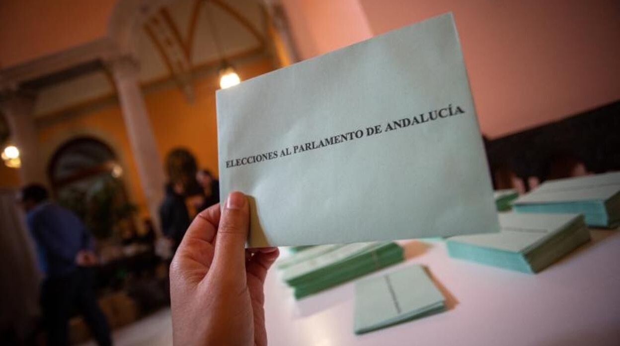 Una persona sostiene un sobre antes de votar en las pasadas elecciones en Andalucía