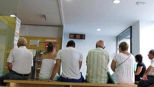 Varias personas, en el interior de una oficina de desempleo