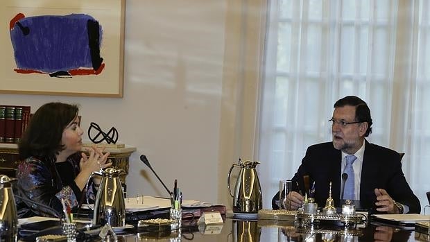 El presidente del Gobierno, Mariano Rajoy, junto a la vicepresidenta, Soraya Sáenz de Santamaría, preisidiendo el Consejo de Ministros