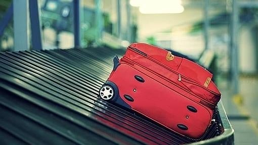 Una maleta en una cinta transportada de aeropuerto