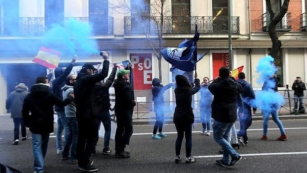 Una veintena de ultras protestan con botes de humo ante la sede del PSOE