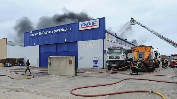 Los bomberos trabajando para extinguir el fuego declarado en el taller de DAF en Burgos