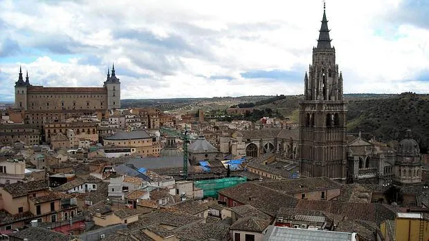 En primer plano, vista de la torre de la Catedral. Al fondo el Alcázar