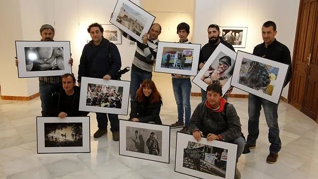 Algunos de los fotógrafos participantes en la muestra enseñan sus imágenes
