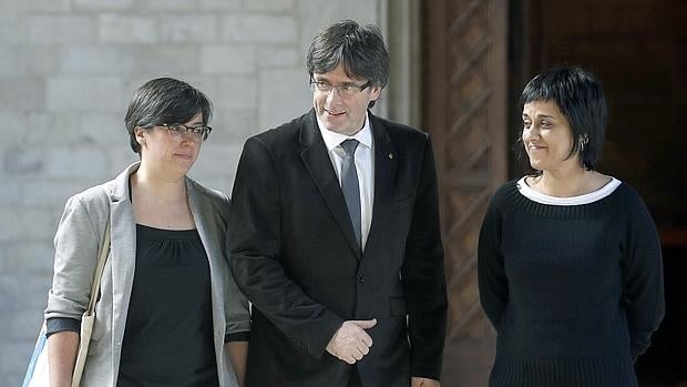 El presidente de la Generalitat Joan Puigdemont con las representantes de la CUP, Mireia Boya (i) y Anna Gabriel