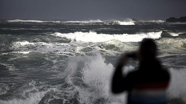 Un hombre hace fotos al fuerte oleaje registrado este domingo en La Coruña