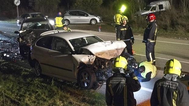 Los bomberos junto a dos vehículos implicados en un accidente