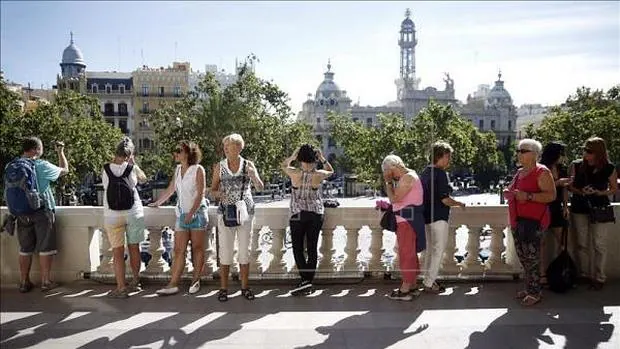 Imagen de unos turistas en el balcón del Ayuntamiento de Valencia