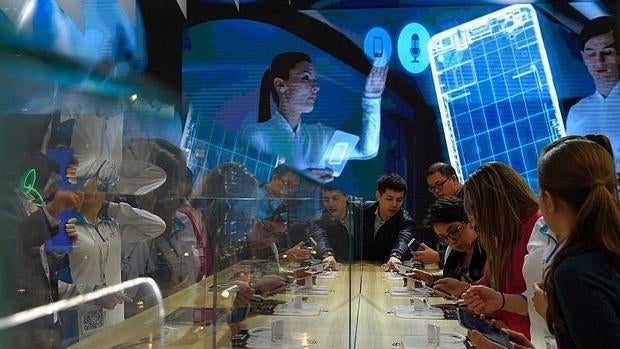 Varios viistantes prueban móviles nuevos en el Mobile World Congress 2016 de Barcelona