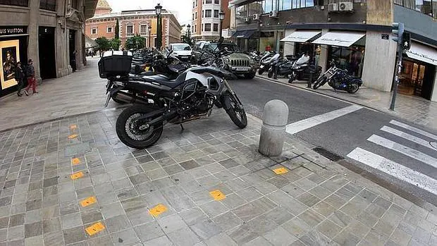 Imagen de una calle de Valencia con varios avisos de la grúa