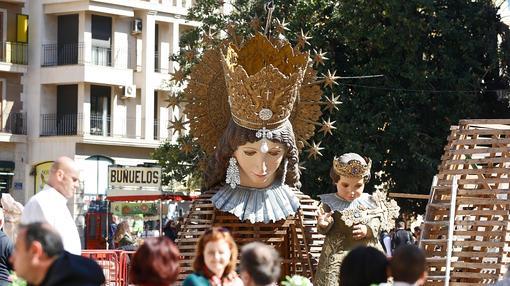 Unos turistas toman un refresco ante la imagen de la Virgen de los Desamparados