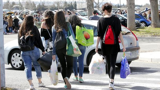 Jóvenes cargados con bolsas de comida y bebida se dirigen a La Peraleda