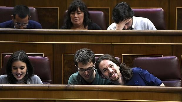 Iglesias bromea hoy en el Congreso con Errejón; a su lado, Irene Montero y detrás, con camisa blanca, Rafa Mayoral