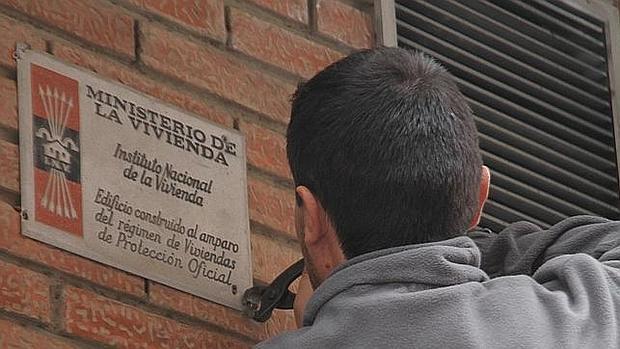 Un operario retira una placa del Ministerio de la Vivienda de la dictadura en un edificio de Valencia