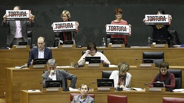 Diputados de Bildu sostienen los carteles de «tortura»