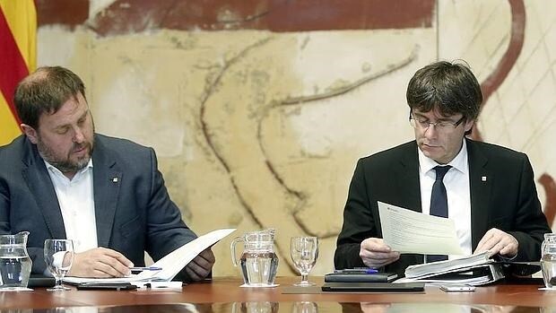 Oriol Junqueras (ERC) y Carles Puigdemont (Convergencia), en una reunión del gobierno de la Generalitat