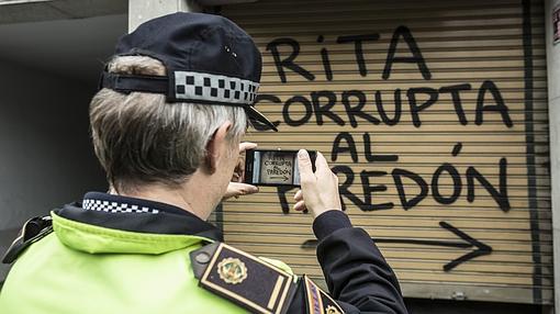 Un policía toma imágenes de la pintada contra Rita Barberá