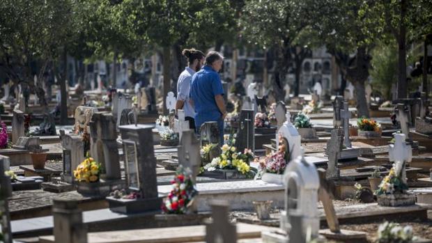 Dos vecinos visitan una lápida en el cementerio municipal de Valencia