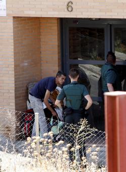 Dos agentes charlan con uno de los desalojados