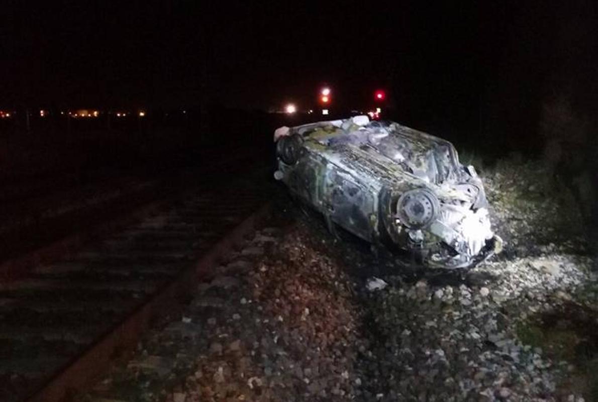 Estado en que quedó el vehículo, totalmente calcinado, junto a las vías del tren