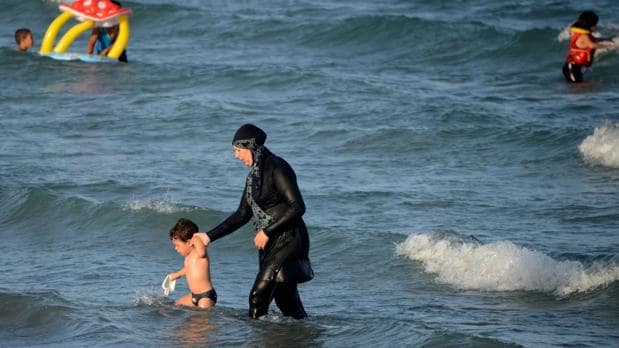Una mujer ataviada con un «burkini» en una playa de Túnez