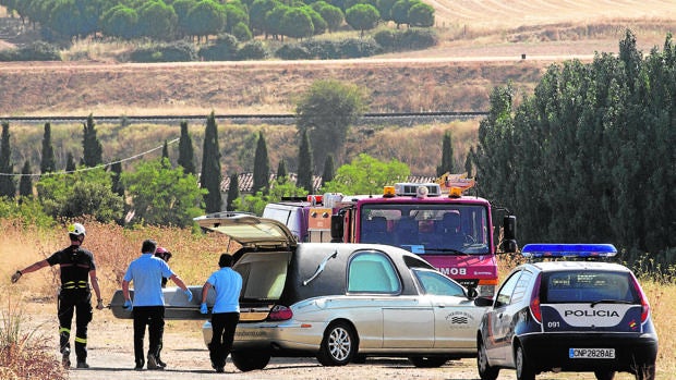 Los servicios funerarios y los bomberos, tras rescatar el cuerpo sin vida de la víctima