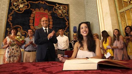 La gimnasta firmando en el libro de honor del ayuntamiento.