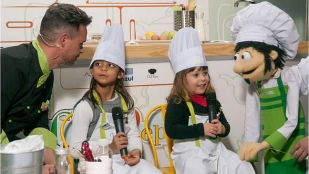 Los chefs Pepo y Miguel con dos niñas en el taller de comida sana