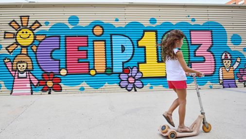 Un niña juega delante de uno de los barracones del Ceip 103