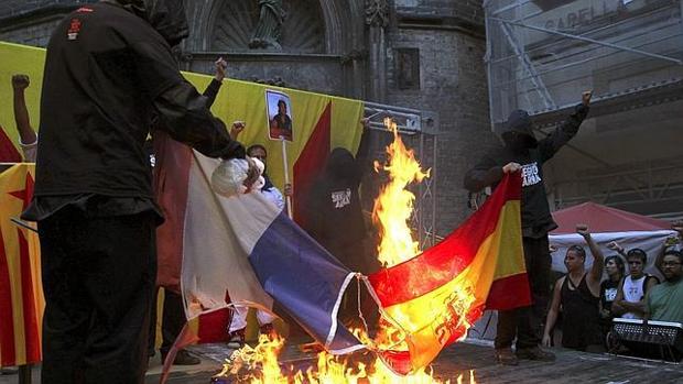 Imagen de 2012 en la que varios manifestantes queman una bandera de España jaleados por la multitud