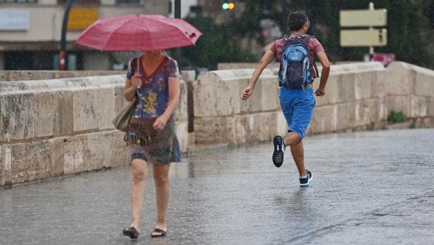 Una mujer se protege de la lluvia en Valencia