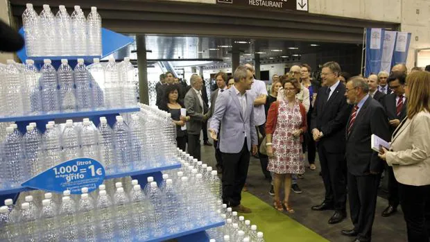 Puig con directivos de Aguas de Valencia y público, junto a la escultura hecha con mil botellas de agua