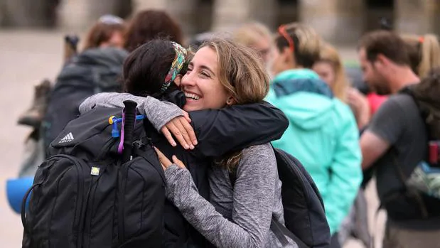 Dos peregrinas se abrazan tras culminar el Camino de Santiago en la plaza del Obradoiro