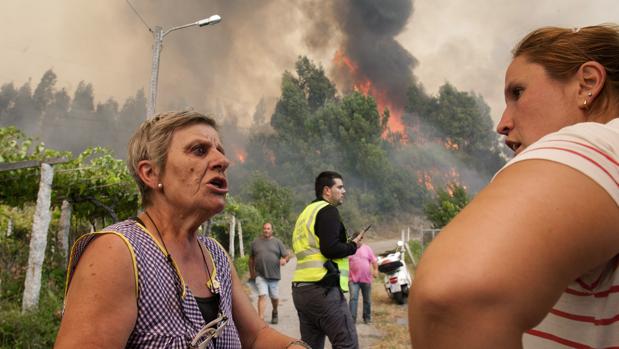 Dos vecinas de Arbo (Pontevedra) conversan durante un incendio forestal en la localidad