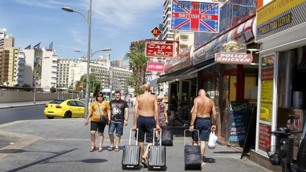 Turistas británicos pasean por una calle comercial de Benidorm