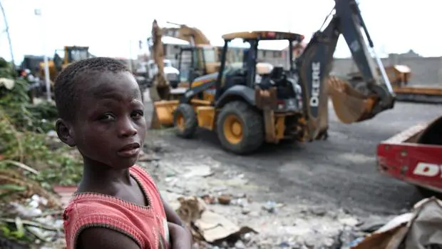 Un niño haitiano, ante las máquinas que trabajan en la reconstrucción de las zonas devastadas por el huracán