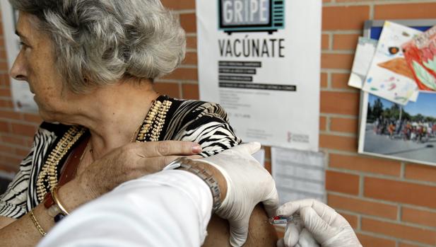 Una mujer recibe la vacuna contra la gripe en un centro de salud de Valencia