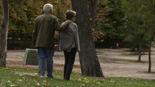 Una pareja de ancianos pasea por un parque