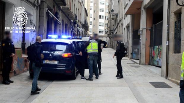 Los agentes introducen en el vehículo a uno de los arrestados por el asalto al cura en Vigo