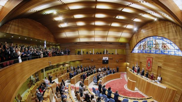 Diputados e invitados en la tribuna de público cantan el himno gallego durante la apertura de la Legislatura