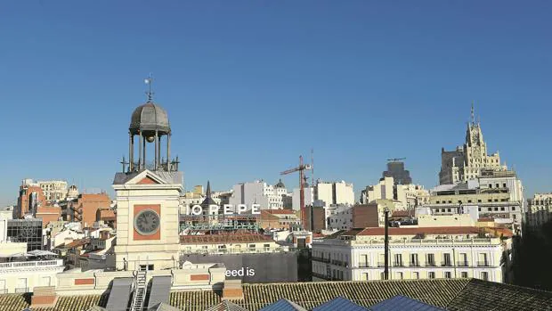 El reloj de la Puerta del Sol, sobre los tejados del centro de Madrid