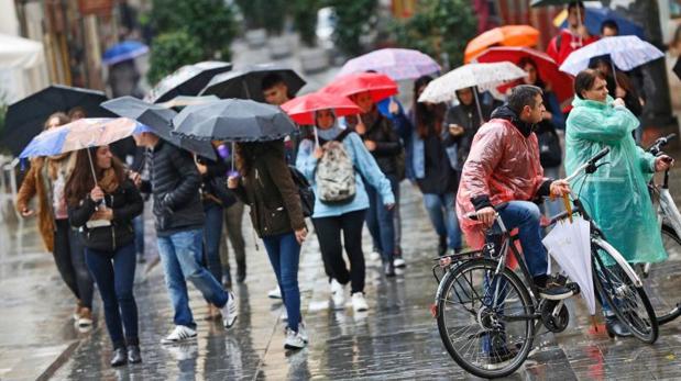 Transeúntes se protegen de la lluvia este martes en la ciudad de Valencia