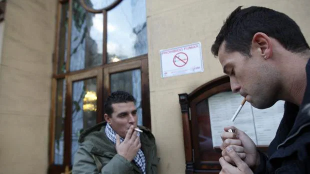 Dos hombres fuman en una calle de Madrid