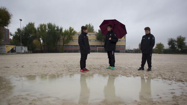 Jugadores del Alzona, sobre el campo de fútbol, en un día de lluvia