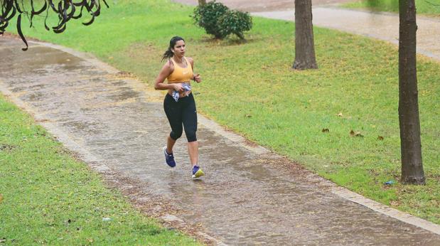 Una joven corre por el Jardín del Turia tras el episodio de lluvias