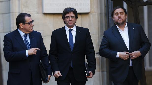 Puigdemont, en el centro, flanquado por el cosejero Jané y el vicepresidente Junqueras