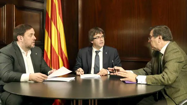 El vicepresidente catalán y conseller de Economía y Hacienda, Oriol Junqueras; el presidente del Govern, Carles Puigdemont; y un secretario judicial del Tribunal Superior de Justicia de Cataluña (TSJC)