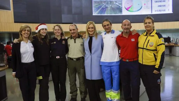 La presidenta de la Comunidad de Madrid, Cristina Cifuentes (4d), posa junto a algunos trabajadores de los distintos servicios de emergencias que forman el equipo de guardia en Nochebuen
