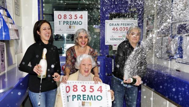 Agraciados celebran el premio en la administración de lotería de Torrent