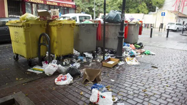 Una fila de contenedores atestados de basura, en Vallecas